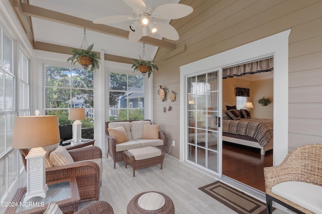 sunroom / solarium featuring beam ceiling and ceiling fan