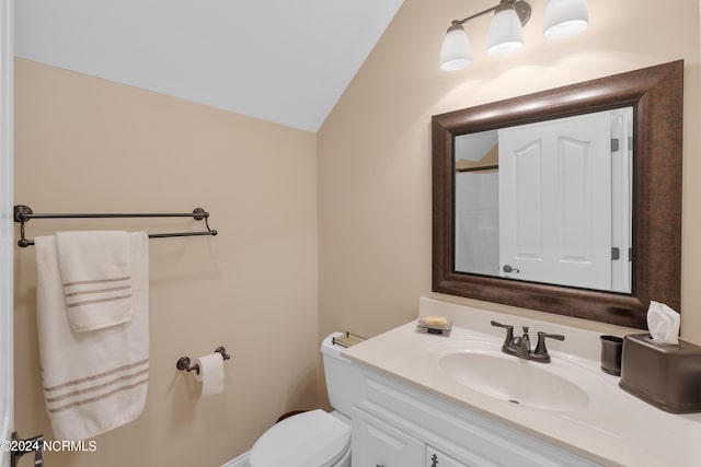 bathroom featuring lofted ceiling, toilet, and vanity