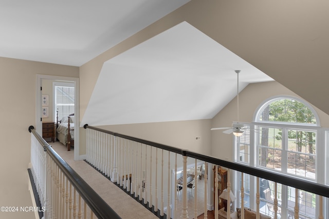 hall with vaulted ceiling and an upstairs landing