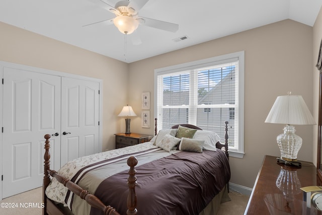 carpeted bedroom featuring ceiling fan, visible vents, baseboards, vaulted ceiling, and a closet