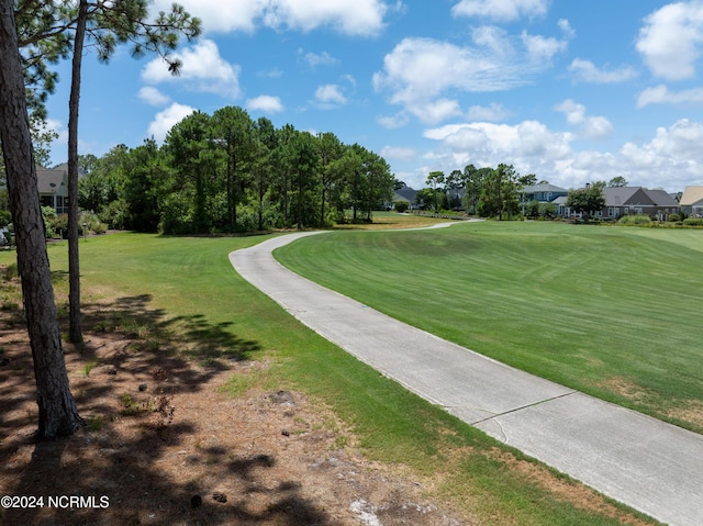 view of community with a yard and golf course view