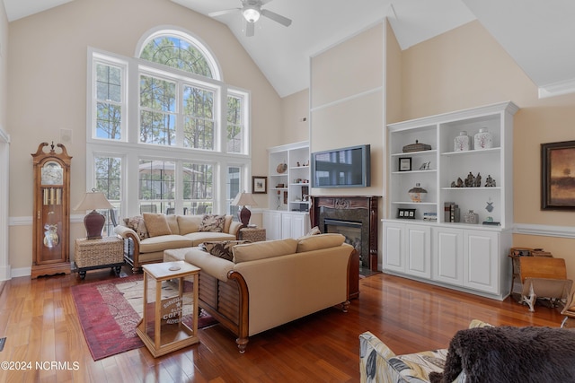 living room with ceiling fan, high vaulted ceiling, hardwood / wood-style floors, and a high end fireplace