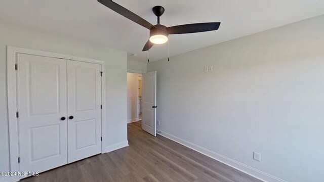 unfurnished bedroom featuring a ceiling fan, a closet, baseboards, and wood finished floors