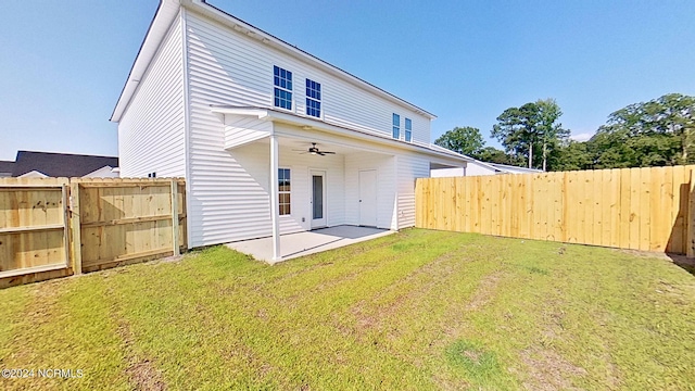 rear view of property with ceiling fan, a yard, a patio, and a fenced backyard