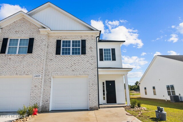 view of front of home featuring a garage, concrete driveway, brick siding, and central AC