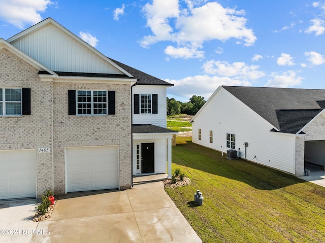 view of front of house featuring a front yard, brick siding, driveway, and central AC unit