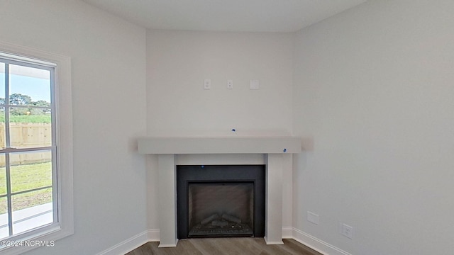 interior details with a fireplace, baseboards, and wood finished floors