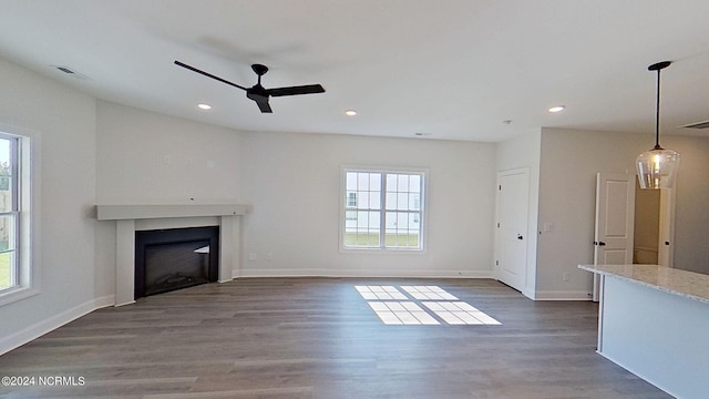 unfurnished living room with recessed lighting, dark wood-style flooring, a fireplace, and baseboards