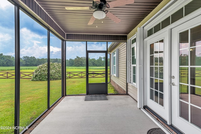 unfurnished sunroom with ceiling fan