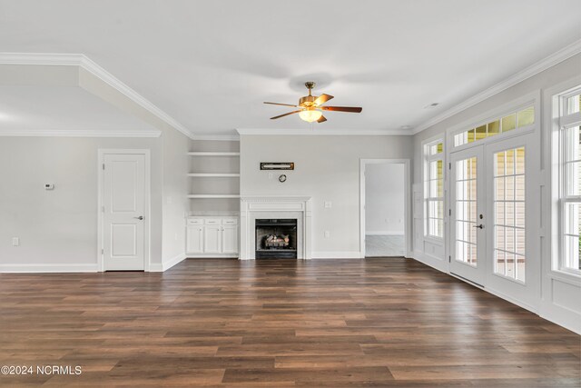 unfurnished living room with ceiling fan, wood-type flooring, a wealth of natural light, and built in features