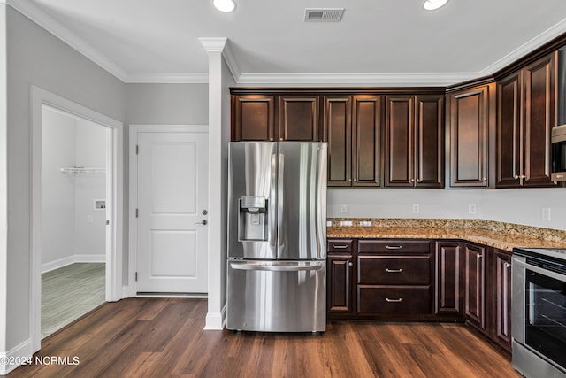 kitchen featuring appliances with stainless steel finishes, dark hardwood / wood-style flooring, and light stone countertops