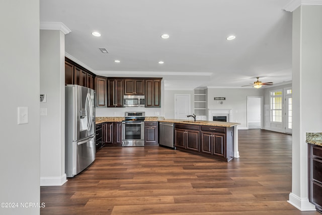 kitchen featuring ceiling fan, appliances with stainless steel finishes, dark hardwood / wood-style flooring, and light stone countertops