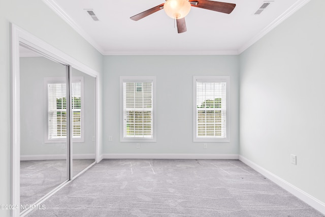 unfurnished bedroom featuring crown molding, multiple windows, and carpet