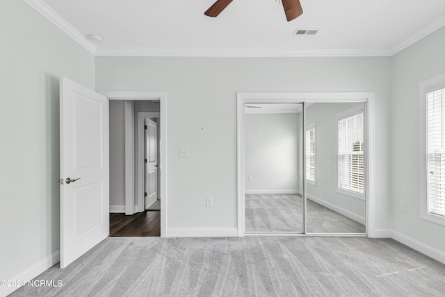 unfurnished bedroom featuring ornamental molding, carpet flooring, a closet, and ceiling fan