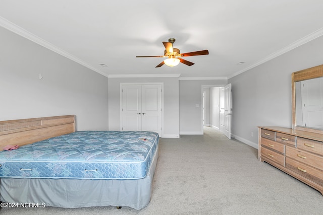 bedroom featuring ceiling fan, crown molding, a closet, and carpet