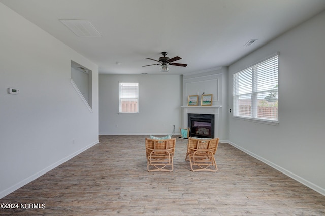 unfurnished living room with a fireplace, light hardwood / wood-style flooring, and ceiling fan