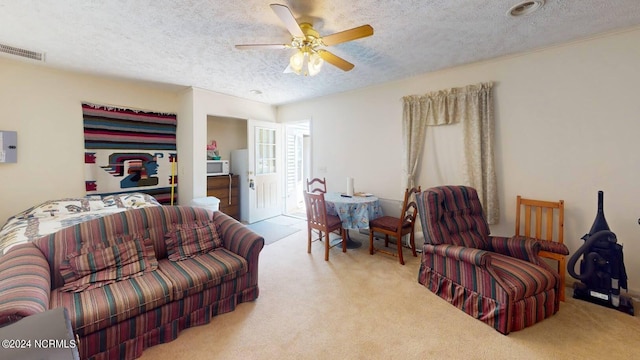 carpeted living room featuring a textured ceiling and ceiling fan