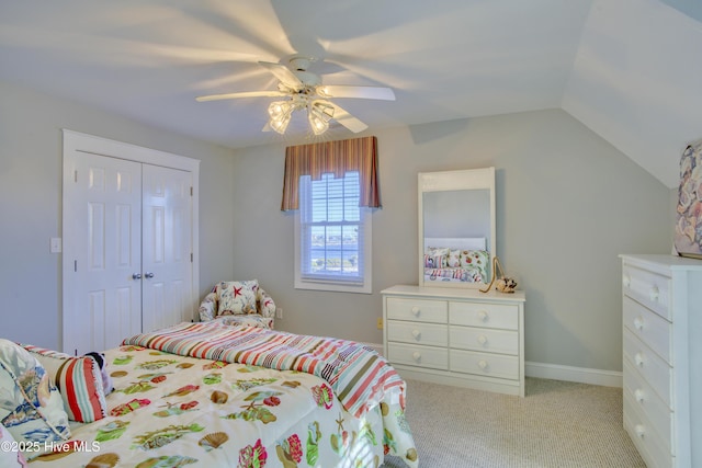 bedroom featuring light colored carpet, a ceiling fan, baseboards, vaulted ceiling, and a closet