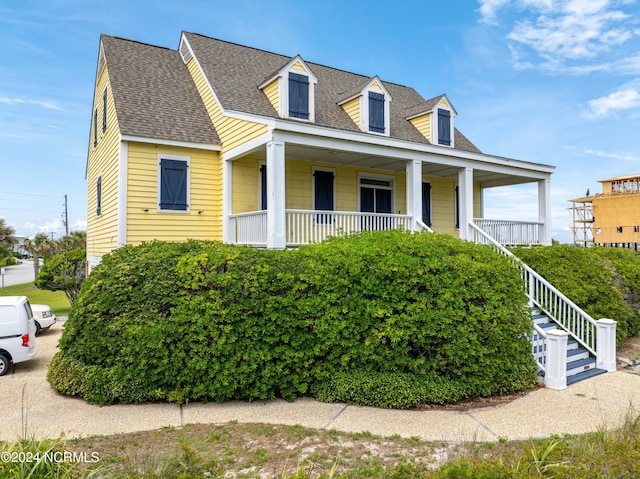 cape cod house with stairs, a porch, and a shingled roof