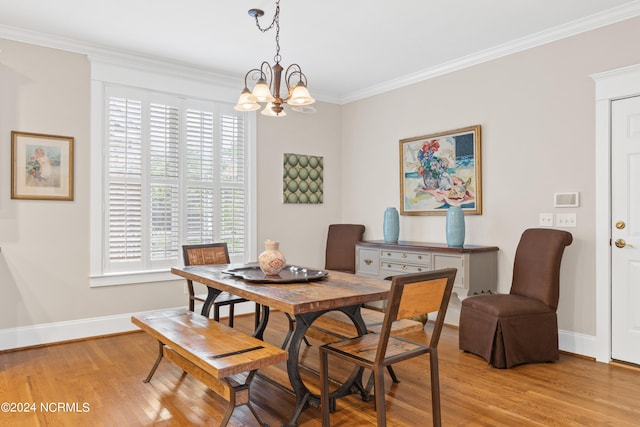 dining space with crown molding, light wood-type flooring, and a chandelier