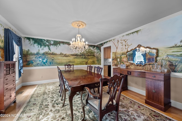 dining area with light hardwood / wood-style floors, an inviting chandelier, and crown molding