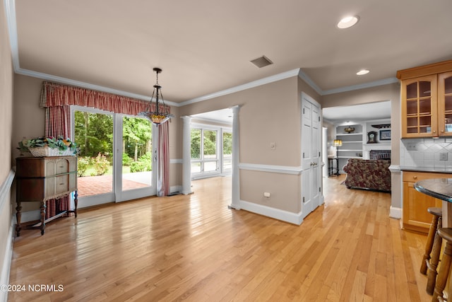 dining space with light wood-type flooring and ornamental molding