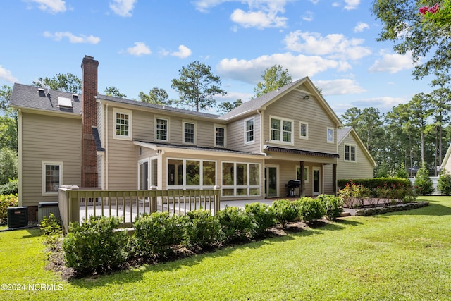 back of house featuring a deck, cooling unit, and a lawn