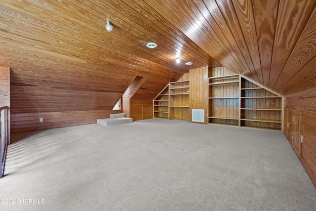 additional living space featuring built in shelves, wooden walls, carpet flooring, vaulted ceiling, and wooden ceiling