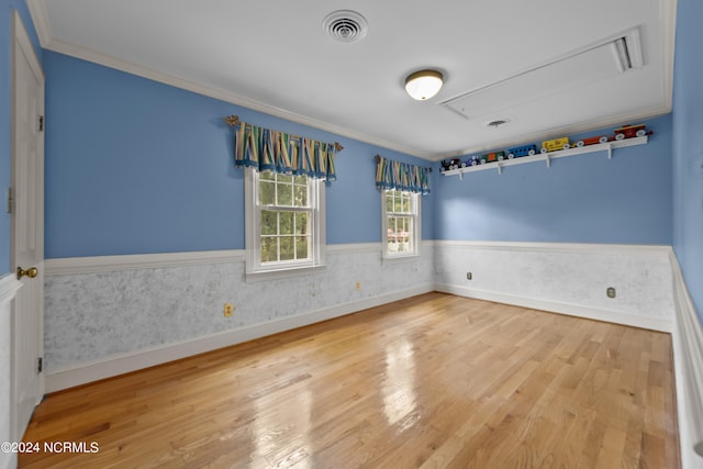 unfurnished room with light wood-type flooring and crown molding