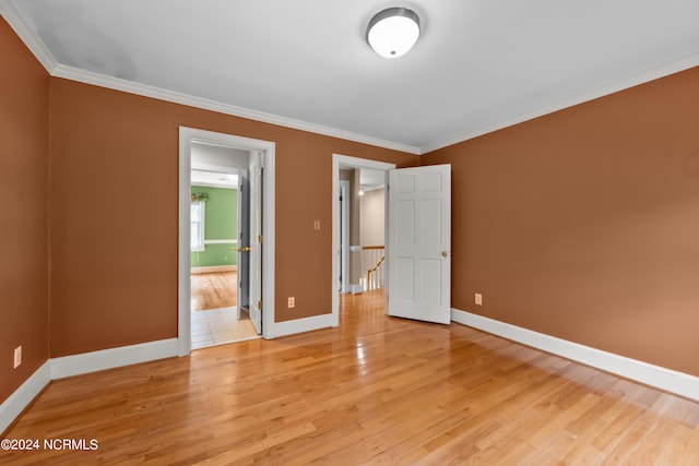 unfurnished bedroom featuring light wood-type flooring and crown molding