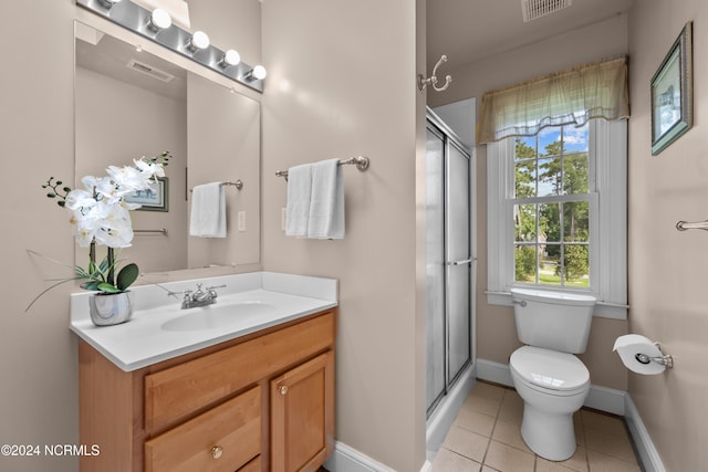 bathroom with tile patterned flooring, a shower with shower door, vanity, and toilet