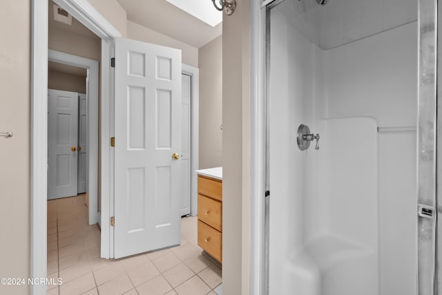 bathroom featuring tile patterned flooring, vanity, and walk in shower