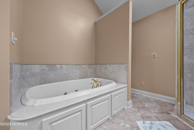 bathroom featuring tile patterned floors, vaulted ceiling, and a bathing tub