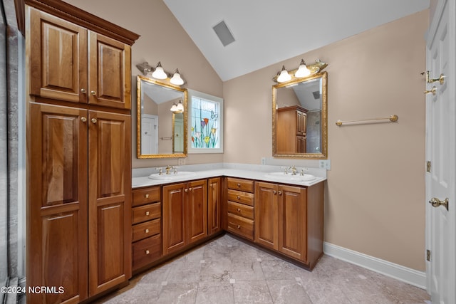 bathroom with vaulted ceiling, vanity, and tile patterned floors