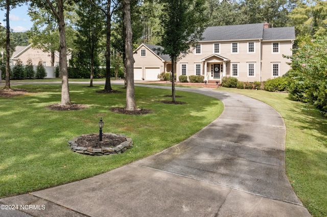 colonial-style house featuring a garage and a front yard