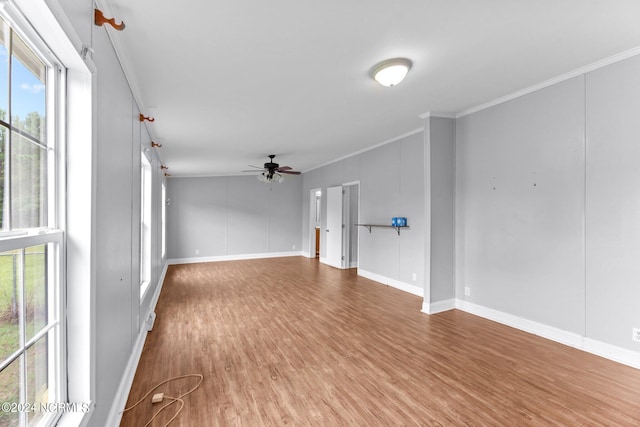 unfurnished living room with baseboards, wood finished floors, a ceiling fan, and crown molding