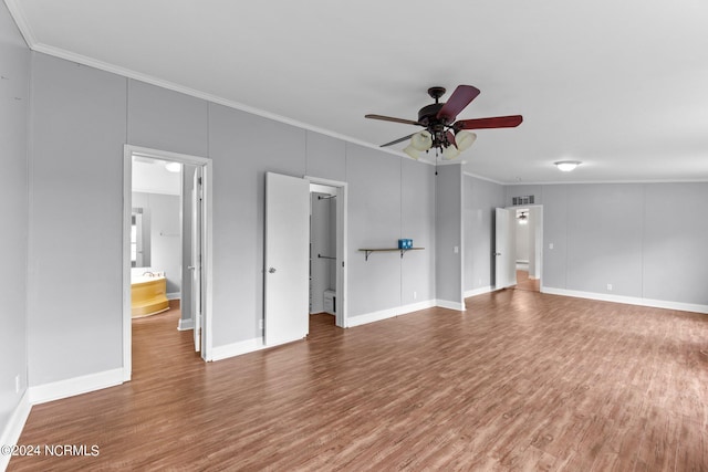 unfurnished living room featuring ceiling fan, crown molding, baseboards, and wood finished floors