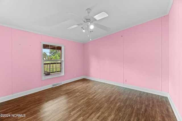 spare room with ceiling fan, wood finished floors, visible vents, and crown molding