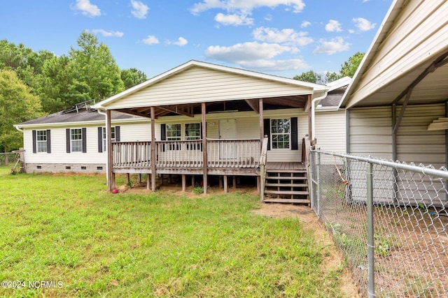 rear view of property with a lawn and a wooden deck