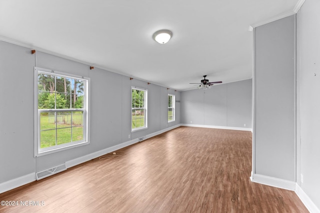 unfurnished room featuring baseboards, visible vents, ceiling fan, and wood finished floors