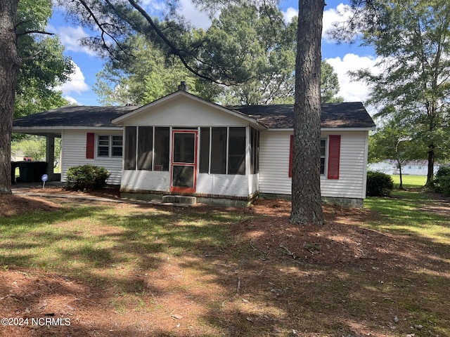 view of front of house with a sunroom and a front lawn