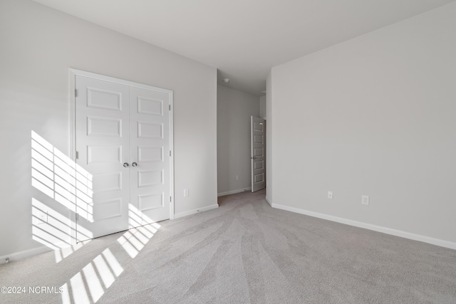 unfurnished room featuring light carpet