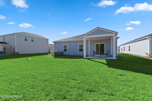 rear view of property with a patio and a yard