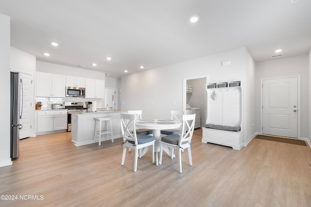 dining room with sink and light wood-type flooring