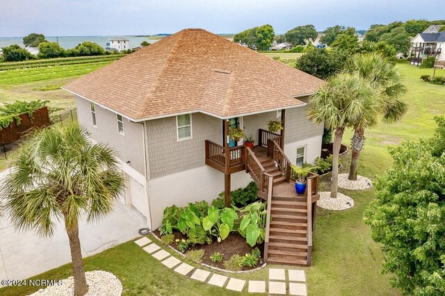 view of front facade with a garage, a water view, and a front lawn