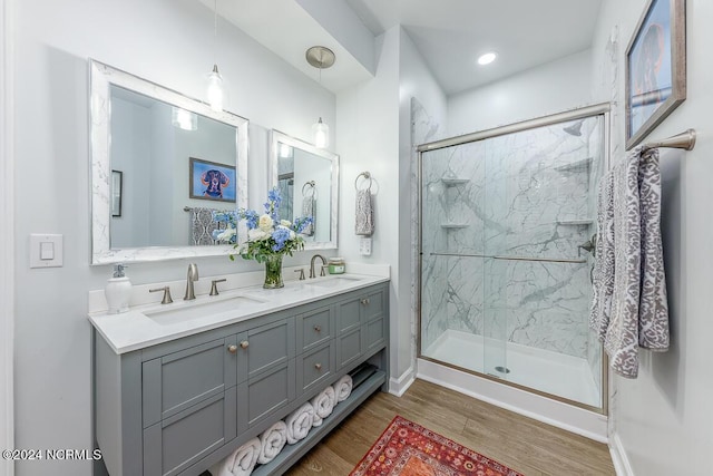 bathroom featuring vanity, hardwood / wood-style flooring, and a shower with shower door