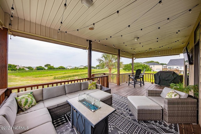 wooden deck with an outdoor living space with a fire pit