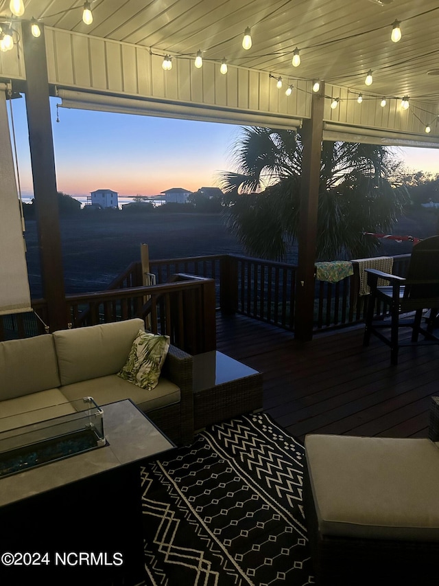 deck at dusk featuring outdoor lounge area