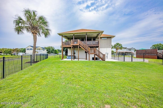 rear view of property featuring a patio, a yard, and a deck