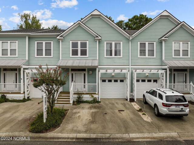 view of property with a garage and a porch